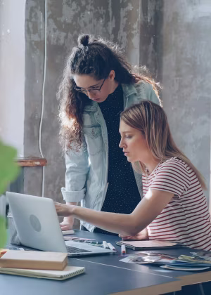 Two students working together on a laptop.